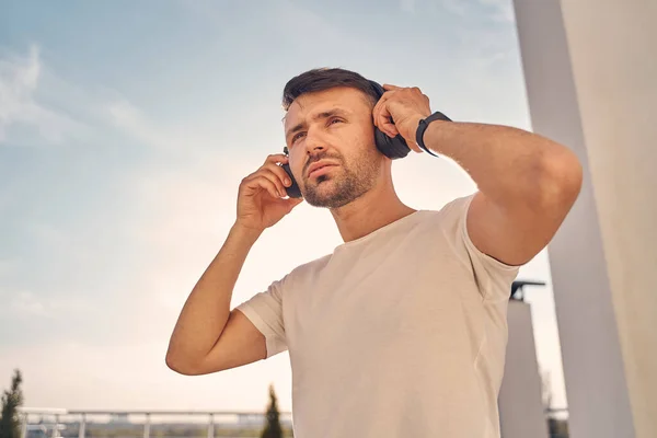 Bonito morena homem ouvindo música fora — Fotografia de Stock