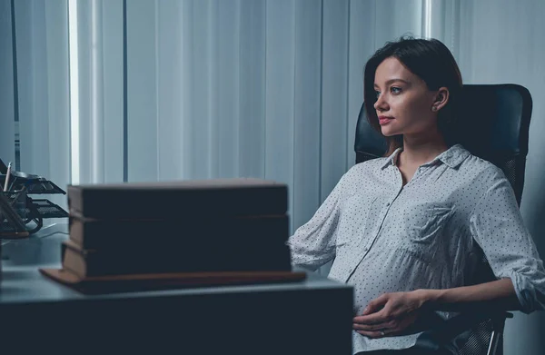 Beautiful pregnant woman working late in office — Stock Photo, Image