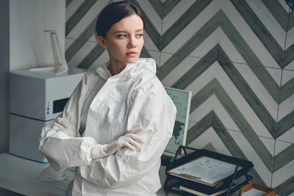 Vacker ung kvinna i sterila handskar stående på kontoret — Stockfoto