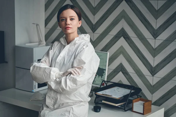 Elbűvölő fiatal nő steril kesztyűben áll az irodában — Stock Fotó