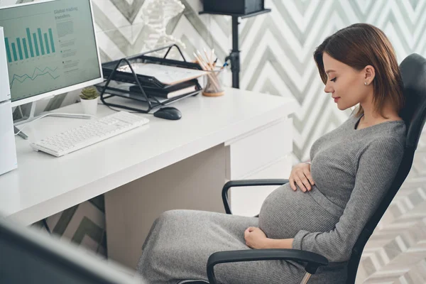 Vacker gravid dam sitter vid bordet på jobbet — Stockfoto