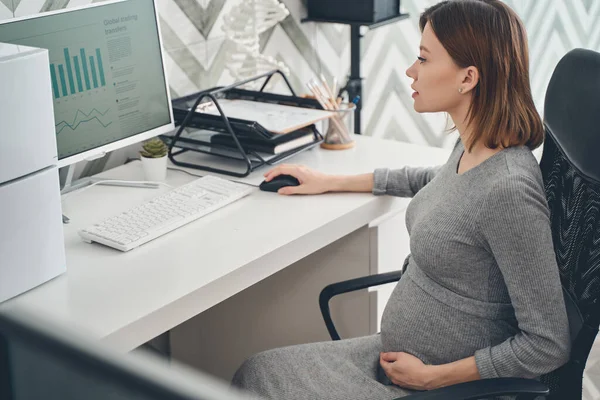 Hermosa mujer embarazada utilizando el ordenador en el trabajo — Foto de Stock