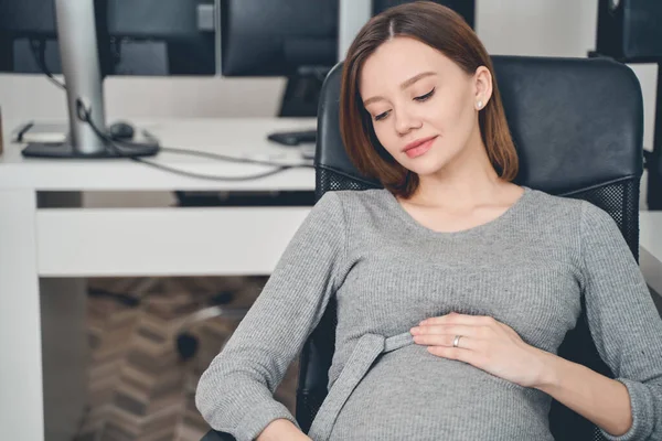 Aranyos terhes nő ül irodai szék a munkahelyen — Stock Fotó