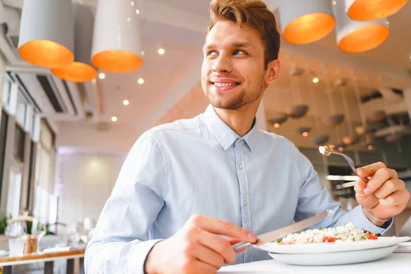 Beau jeune homme déjeunant au restaurant — Photo