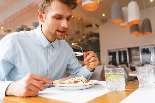 Hezký mladý muž obědvá v restauraci — Stock fotografie