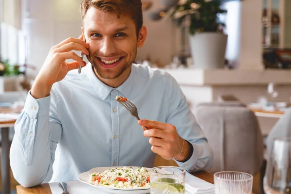 Joven alegre teniendo conversación telefónica en la cafetería —  Fotos de Stock