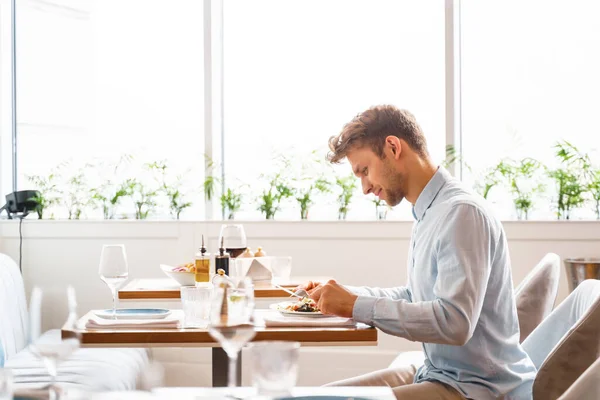 Stilvoller junger Mann beim Abendessen im Restaurant — Stockfoto