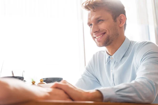 Cheerful young man holding hand of lady — Stock Photo, Image