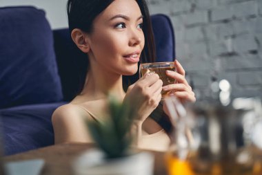 Bir fincan çay tutan güzel genç bayan.