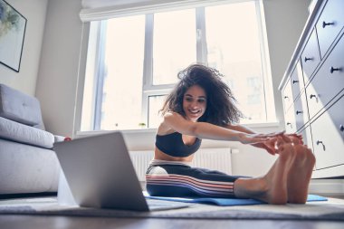 Çevrimiçi ders izleyen mutlu genç bir kadın