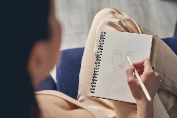 Young woman drawing in notebook at home — Stock Photo, Image