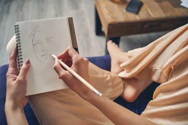 Νεαρή κοπέλα ζωγραφίζει στο σημειωματάριο στο σπίτι — Φωτογραφία Αρχείου