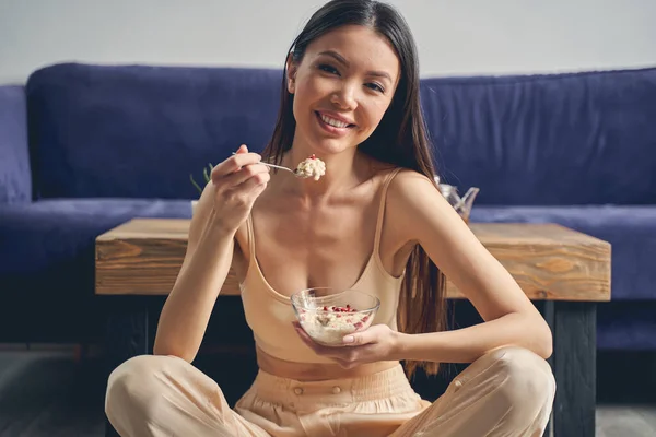 Glada ung kvinna äter havregryn hemma — Stockfoto