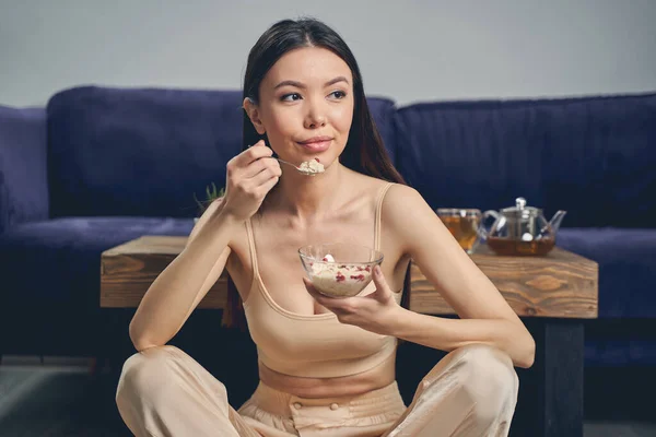 Attraktiv ung dam äter havregryn hemma — Stockfoto