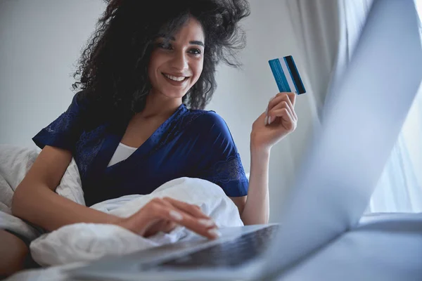 Schöne brünette weibliche Person schaut auf ihren Laptop — Stockfoto