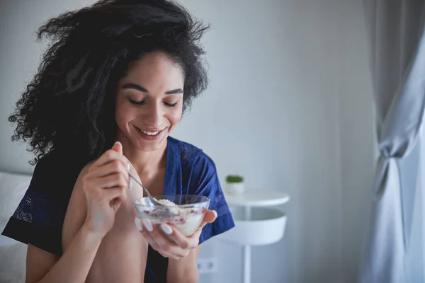 Положительный восторг брюнетка девушка ест завтрак с удовольствием — стоковое фото