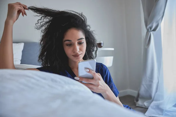 Atento pelo rizado chica leyendo mensaje de ingresos —  Fotos de Stock