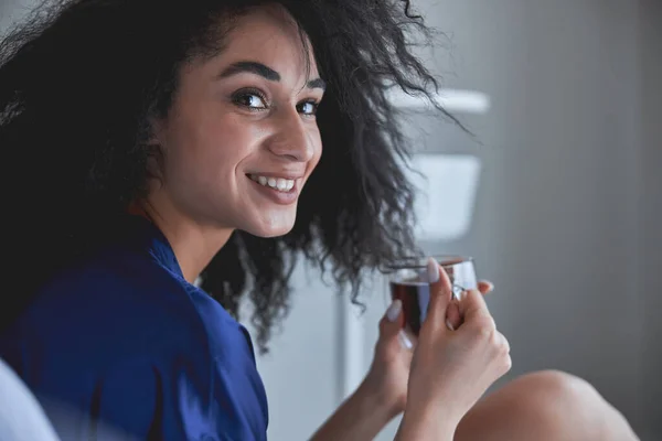 Positive delighted female person enjoying her coffee — Stock Photo, Image