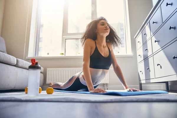 Jovem de cabelos encaracolados mulher fazendo exercício matinal — Fotografia de Stock