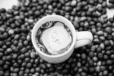 Masanın üzerinde kavrulmuş ve öğütülmüş fasulyelerle hazırlanmış bir fincan kahve. Tüketim için sıcak ve enerji içeceği. Brezilya 'dan kahve.