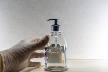 Covid-19 'a karşı alkol jeli ve eldiven. Şiddetli akut solunum sendromu 2 'nin (SARS-CoV-2) koronavirüsünden kaynaklanan bulaşıcı bir hastalık. Belirtiler ateş, öksürük ve solunum güçlüğü..