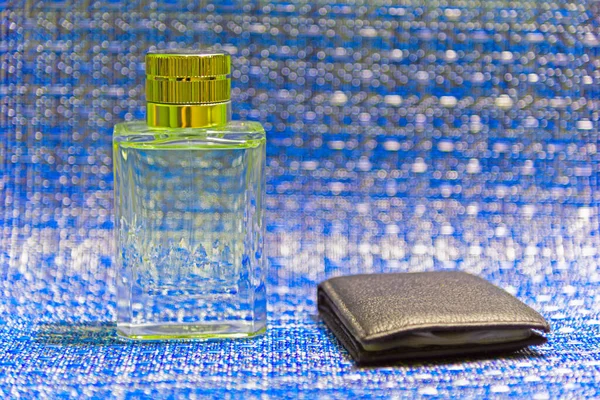 Obraz Butelki Perfum Niebieskim Tle Obok Skórzany Portfel Przechowywania Dokumentów — Zdjęcie stockowe