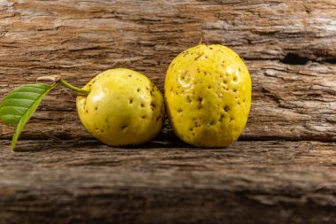 Tahta arka planda izole edilmiş sarımsı pembe guava meyveleri. Tüketim için toplanmış yeşil yapraklı taze guavalar. Brezilya 'dan tropik meyveler. Ahşap dokular. guava yaprakları ve meyveler.