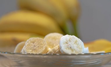 Muzlar kesilip tabakta servis ediliyor. Tropikal meyveli tatlı. Odaklanmamış muz meyveleri. Brezilya 'da ihracat için yapılan meyveler. Dilimlenmiş cüce muzlar..