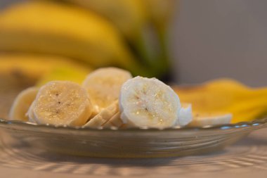 Muzlar kesilip tabakta servis ediliyor. Tropikal meyveli tatlı. Odaklanmamış muz meyveleri. Brezilya 'da ihracat için yapılan meyveler. Dilimlenmiş cüce muzlar..