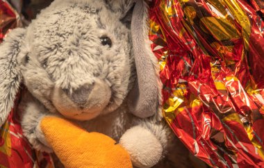 Hasır sepete doldurulmuş tavşan. Paskalya Tavşanı doğurganlığı, doğumu ve ortalama ömrü temsil eden Paskalya sembollerinden biridir. Tatil günü. Çikolatalar..