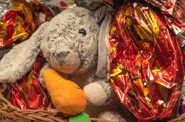 Stuffed rabbit in wicker basket. The Easter Bunny is one of the Easter symbols, used to represent fertility, birth and life expectancy. Holiday. chocolates.