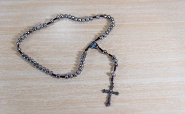 Tespih ve dini haç. Katolikliğin sembolleri. İsa 'nın çarmıha gerilmesinden sonra Hristiyanlar tarafından başlatılan bir hürmet sembolüdür..