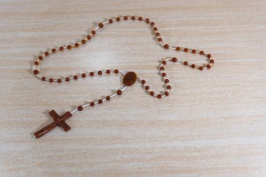 Tespih ve dini haç. Katolikliğin sembolleri. İsa 'nın çarmıha gerilmesinden sonra Hristiyanlar tarafından başlatılan bir hürmet sembolüdür..