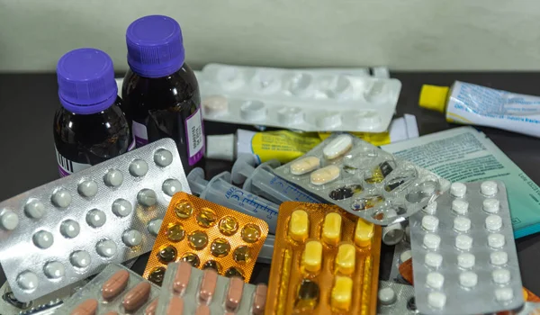 Bottles and pills. A tablet is the solid form of a medicated powder, prepared by compression, with or without added binders. Slots may be provided to allow dose sharing