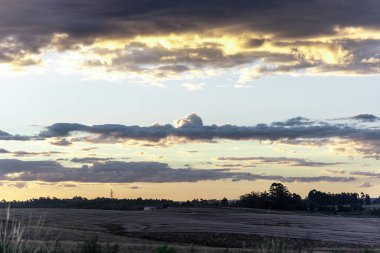Güneş ve bulutlar battı. Dramatik bir gökyüzü. Güney Brezilya 'da çiftlik bölgesi. Yağmur bulutları aydınlandı. Gün batımı manzarası. Brezilya, Uruguay ve Arjantin sınırında Pampa Biomu Tarlaları.
