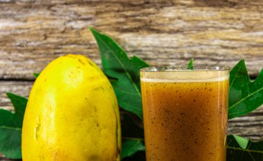 Papaya suyu. Ahşap arka. Taze meyve. Detoks içeceği. Tropik meyve suyu. Papaya yendi. Beta-karoten ve likopenin kaynağı. Sindirim sisteminin meyvesi..