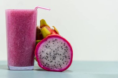 Meyve suyu. Pitaya suyu (Hylocereus polyrhizus). Pembe ya da ejderha meyvesi. Pitaya kaktüsü. Beyaz arka plan. Lifli enerji içeceği. Pullu bitki. Pembe içecek. Antioksidan ve detoks içeceği..