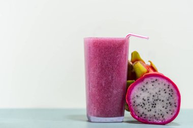 Meyve suyu. Pitaya suyu (Hylocereus polyrhizus). Pembe ya da ejderha meyvesi. Pitaya kaktüsü. Beyaz arka plan. Lifli enerji içeceği. Pullu bitki. Pembe içecek. Antioksidan ve detoks içeceği..