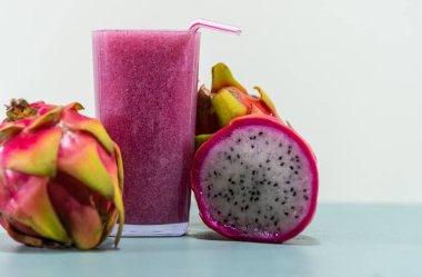 Meyve suyu. Pitaya suyu (Hylocereus polyrhizus). Pembe ya da ejderha meyvesi. Pitaya kaktüsü. Beyaz arka plan. Lifli enerji içeceği. Pullu bitki. Pembe içecek. Antioksidan ve detoks içeceği..