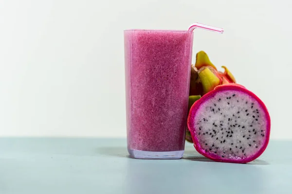 Meyve suyu. Pitaya suyu (Hylocereus polyrhizus). Pembe ya da ejderha meyvesi. Pitaya kaktüsü. Beyaz arka plan. Lifli enerji içeceği. Pullu bitki. Pembe içecek. Antioksidan ve detoks içeceği..