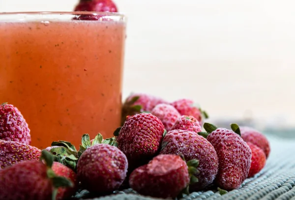 Glass of strawberry juice. White background. Refreshing drink. Frozen drink and fresh strawberry fruits. Red fruits. Tropical fruit. Source of vitamin C. Cold drink.