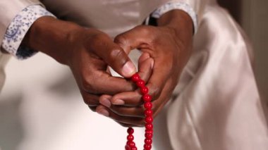 Boncuk kullanırken bir adam dua ediyor