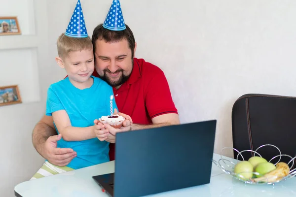 Niño con su padre celebrar cumpleaños en línea, hablando por cuaderno con familiares y amigos —  Fotos de Stock