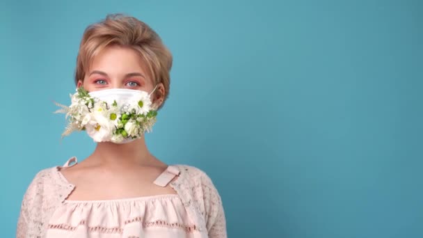 Ansiktsmask design med blommor. Porträtt av vacker kvinna med blå ögon, mode make-up och mask — Stockvideo