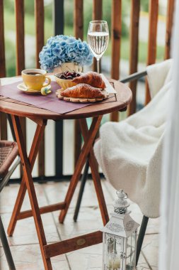 Balkonda sabah kahvaltısı, kruvasan, kahve ve böğürtlen.