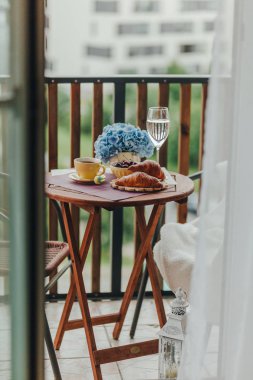 Balkonda sabah kahvaltısı, kruvasan, kahve ve böğürtlen.