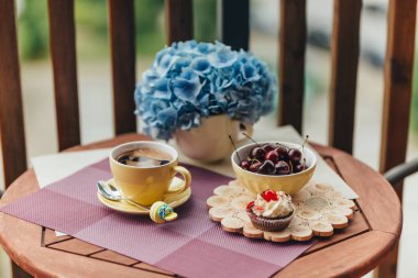 Balkonda sabah kahvaltısı, kruvasan, kahve ve böğürtlen.