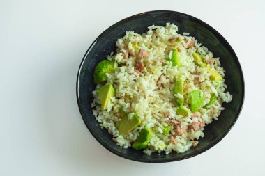 Bir kase porselen, pirinç, avokado ve ton balığı. Akdeniz diyeti, çocukların yemesi için sağlıklı ve iyi bir seçenek..