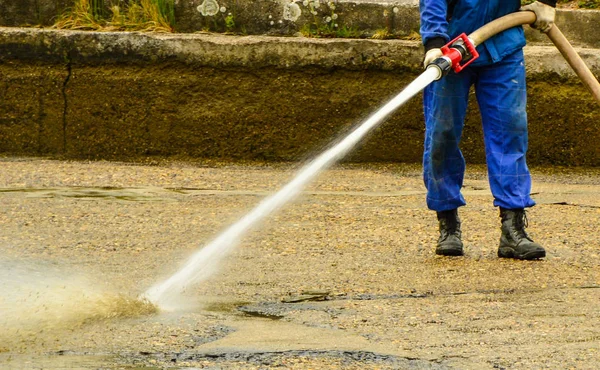 Manguera eliminando lodo después de inundaciones . —  Fotos de Stock