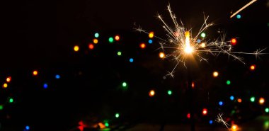 Sparkler and Christmas lights. clipart